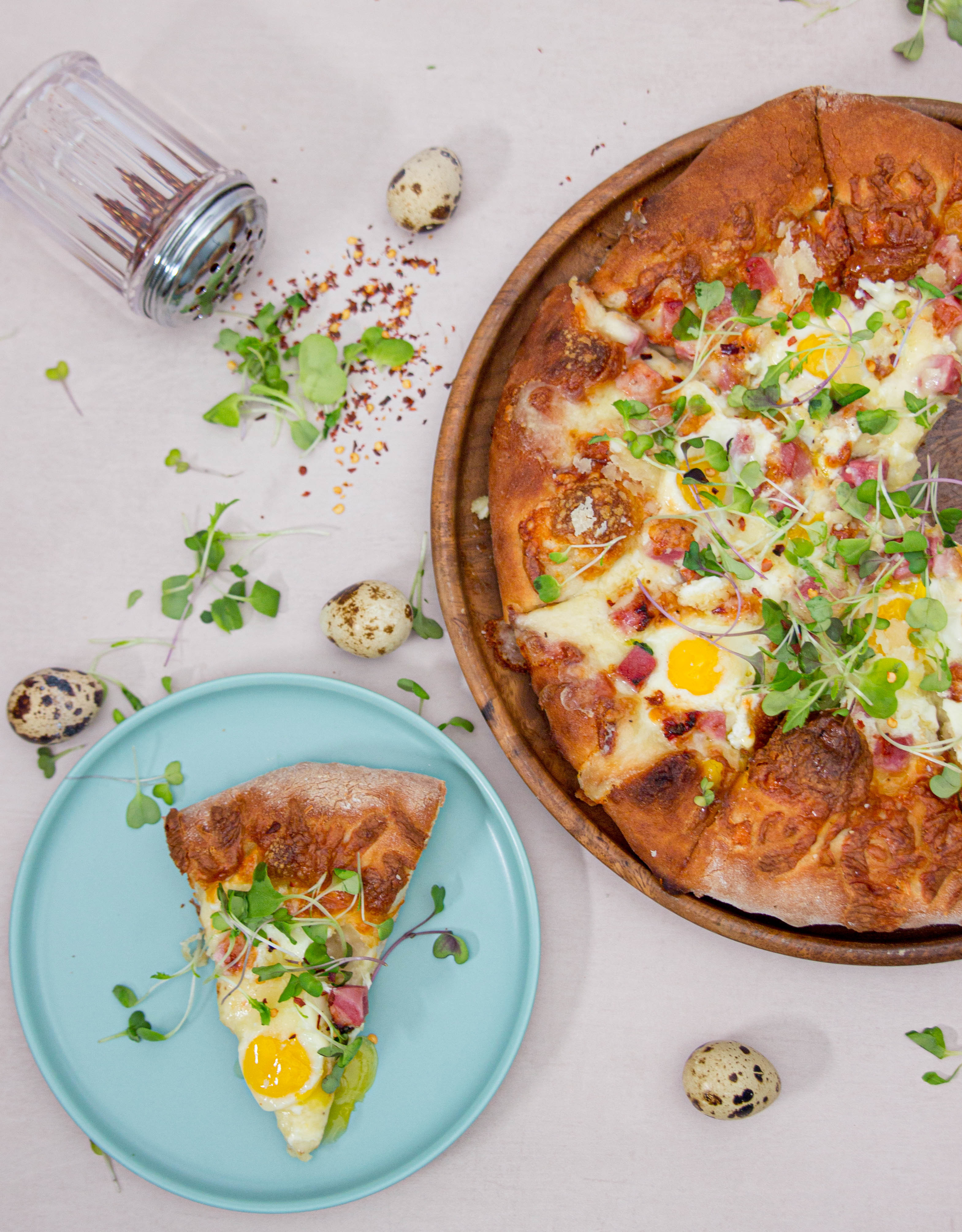 whole pizza and slice pizza with quail egg