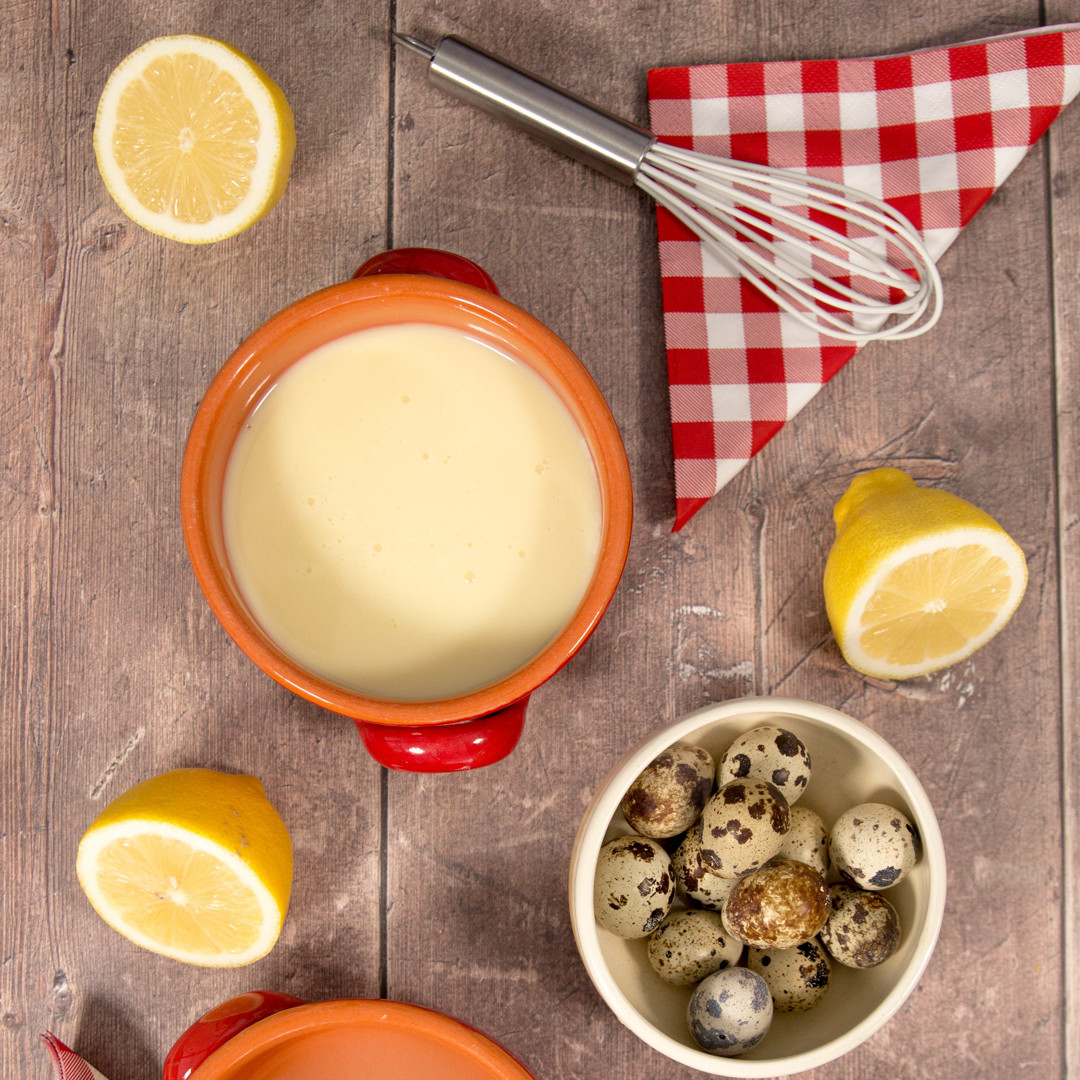 lemon curd in bowl, whisk, halved lemons and quail eggs in bowl